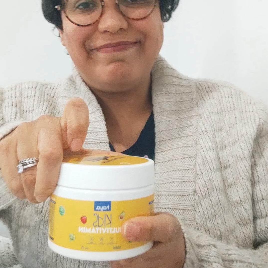 Person holding a container of 'PediaSure' with a plain background